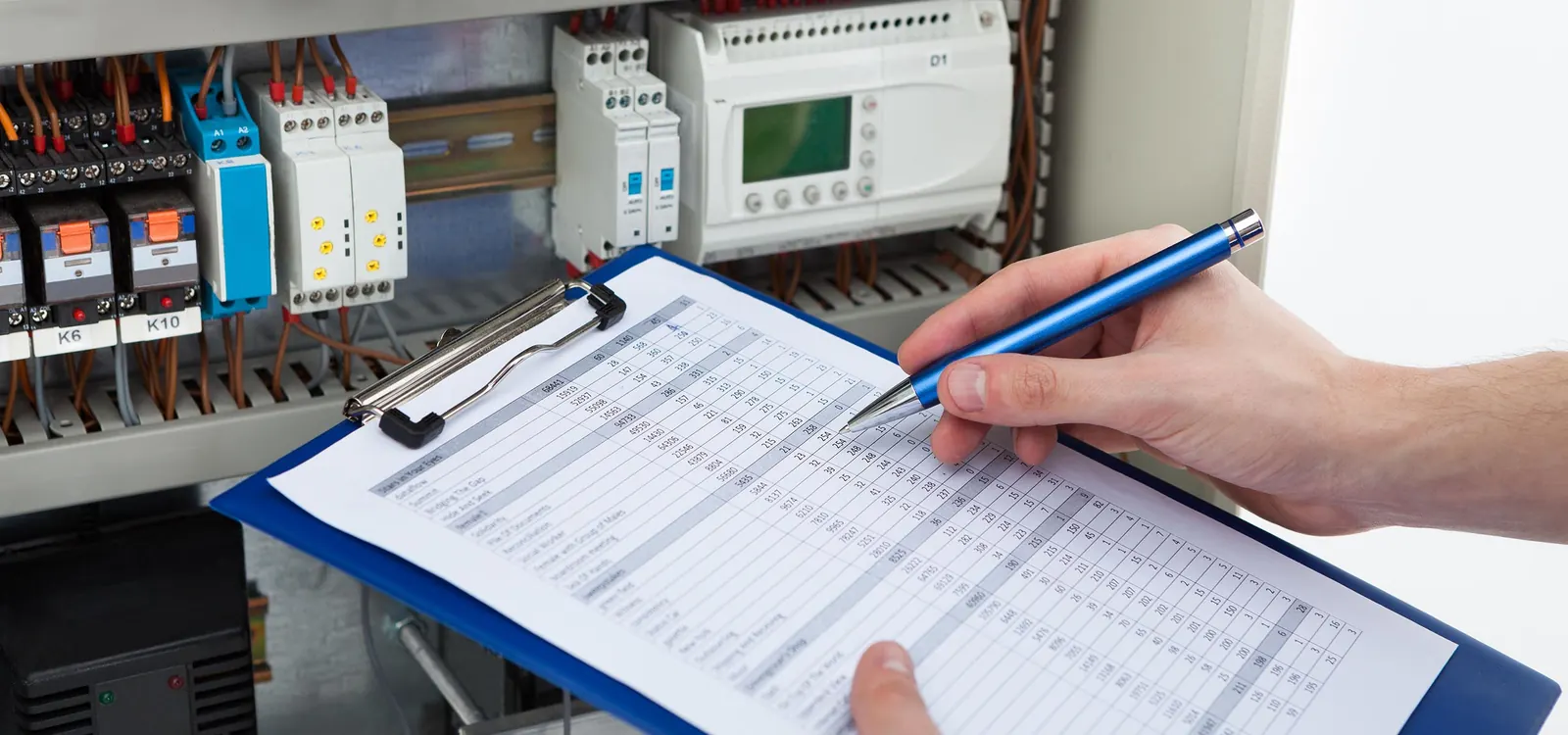 Electrician in Warrington testing a consumer unit and completing an inspection checklist