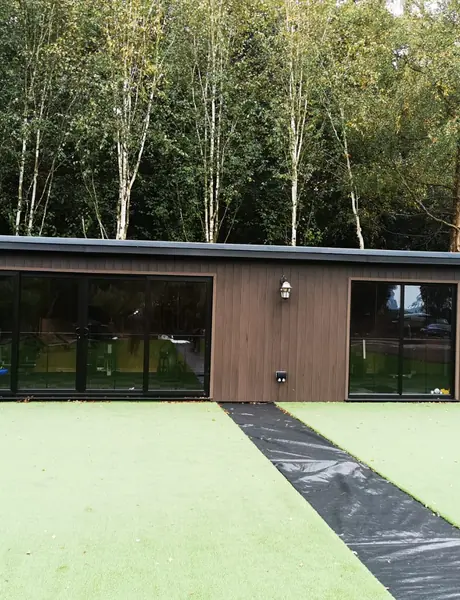 Long garden building with glazed doors and an external electrical installation