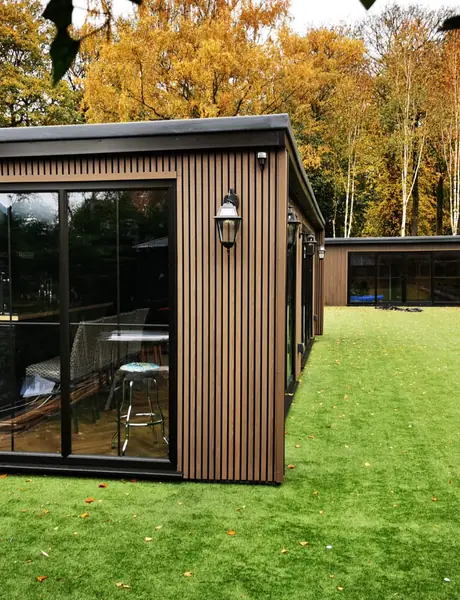 Garden room glazing and external wall lights over an artificial lawn