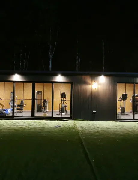 Garden room lit at night by soffit downlights