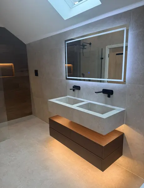 LED mirror above a floating vanity with strip lighting underneath